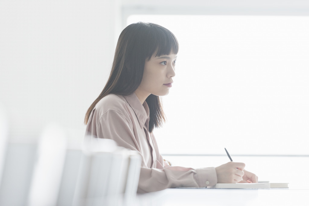 講堂で勉強する女子大生